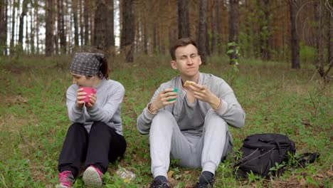 Walk-outdoors.-Young-couple-having-a-snack-in-the-woods