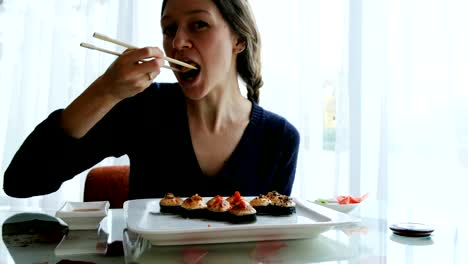 joven-caucásica-comer-sushi-en-un-restaurante-japonés