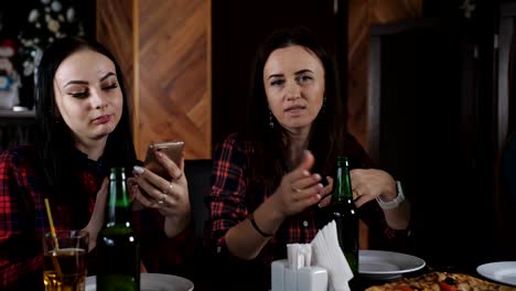 Company-funny-girls-drinking-beer-and-talking-in-the-pizzeria.