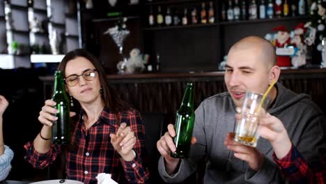 Die-Firma-fröhlich-Freunde-in-der-Pizzeria-am-Tisch-zu-essen,-Pizza,-Bier-trinken-und-tanzen-zur-Musik.