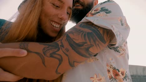 Hipster-girl-playfully-pretending-to-bite-her-boyfriend's-tattooed-arm