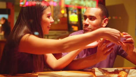 Una-joven-pareja-comiendo-en-un-centro-de-la-ciudad-de-pizzeria