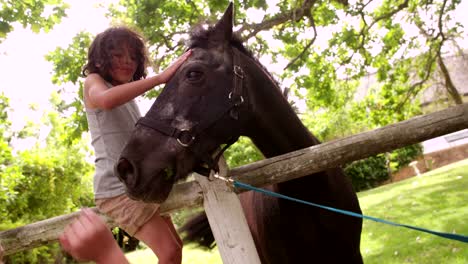 Poco-niño-hispano-caballo-alimentándose-una-zanahoria-y-le-interactivo