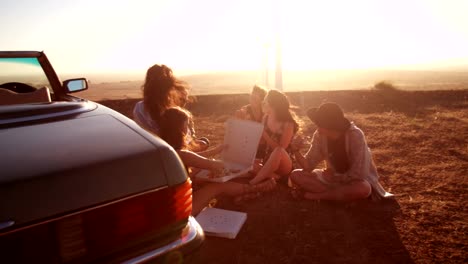 Hipster-Freunde-Essen-Pizza-in-der-Nähe-von-Cabrio-Auto-Straße-Reise