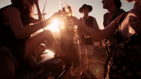 Boho-Friends-toasting-at-sunset-with-beer-and-pizza