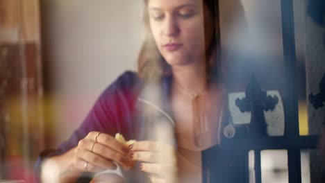 Hipster-Woman-eats-Croissant-in-Coffee-Shop