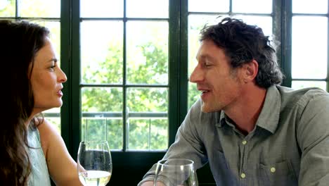 Cute-couple-having-lunch-and-toasting-with-wine