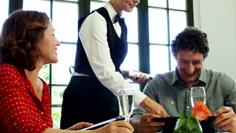 Cute-couple-ordering-form-the-menu-to-the-waitress