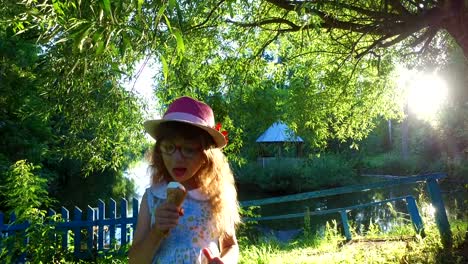 Kleines-Mädchen-mit-langen-Haaren-isst-Eis-im-Park.