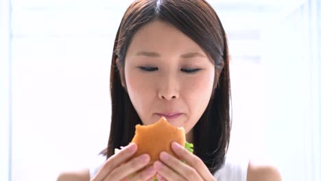 young-woman-eating-hamburger