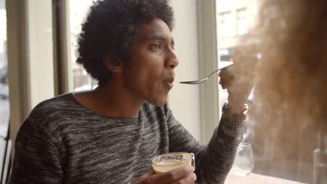 Cerca-de-la-pareja-disfrutando-de-café-y-pastel-en-el-café