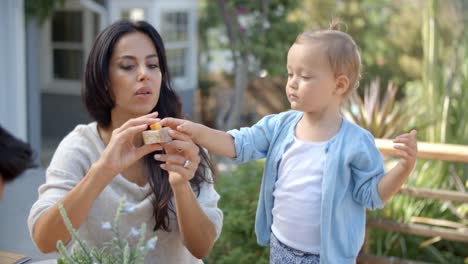 En-casa-la-madre-con-hija-comer-comida-en-el-jardín