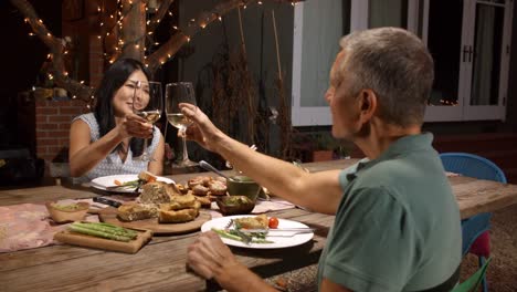 Älteres-Paar-genießen-Mahlzeit-im-Freien-im-Garten