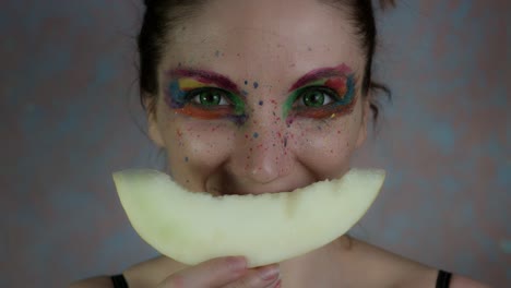 4k-Shot-of-a-Woman-with-Multicoloured-Make-up-with-Melon