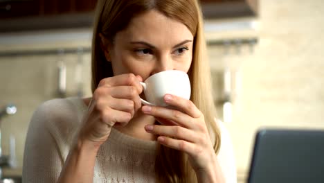 Hermosa-joven-atractivo-comer-su-desayuno-y-trabajando-en-un-ordenador-portátil-en-la-cocina