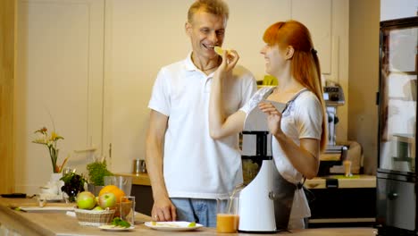 Happy-couple-making-healthy-organic-juice-in-kitchen