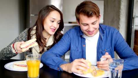 Par-con-teléfono-móvil-desayunando