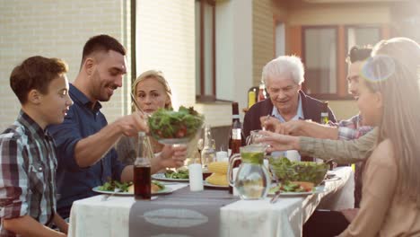 Group-of-Mixed-Race-People-Having-fun,-Communicating-and-Eating-at-Outdoor-Family-Dinner