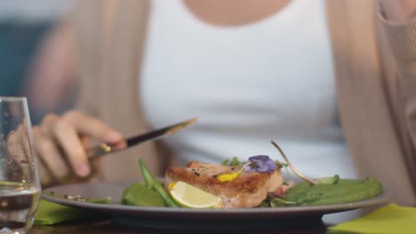 Attraktive-junge-Frau-genießen-Fisch-Steak-im-Luxus-Restaurant