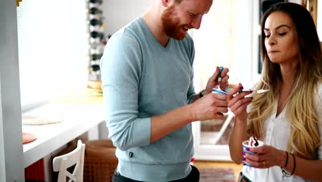 Couple-having-fun-and-laughing-at-home-while-eating-ice-cream