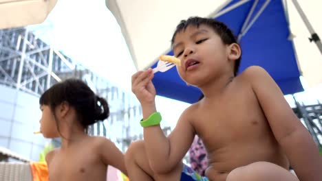 Asiatische-Kind-isst-Pommes-Frites-am-Strand