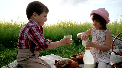 chica-y-chico-con-comida-en-la-naturaleza,-los-niños-felices-en-aire-fresco,-pan-y-lácteos,-comer-durante-el-descanso,-vacaciones-en-la-naturaleza