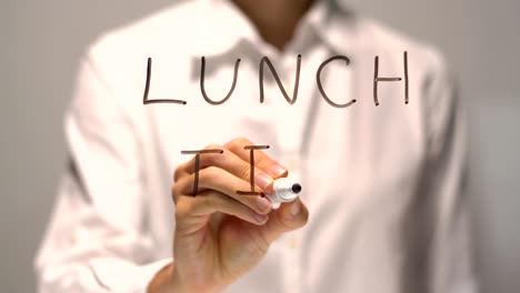 Woman-writing-Lunch-Time-on-transparent-screen.-Businesswoman-write-on-board.