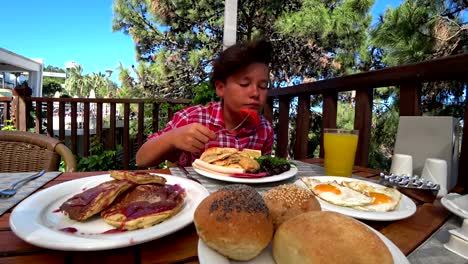 Preteen-boy-eating-breakfast-at-the-outdoor