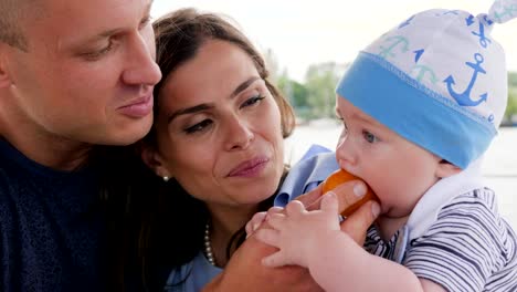 Familien-Segeln,-Baby-seine-ersten-Früchte-zu-essen,-in-Händen-Mütter,-Familien-mit-Kind-am-Wochenende,-Eltern-und-Kinder,-glückliches-Paar