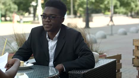 Pleasant-afro-american-man-having-phone-call-during-work-break-with-his-calleague