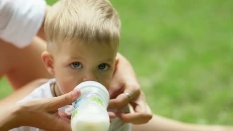 Kleiner-Junge-trinkt-Milch-aus-Babyflasche