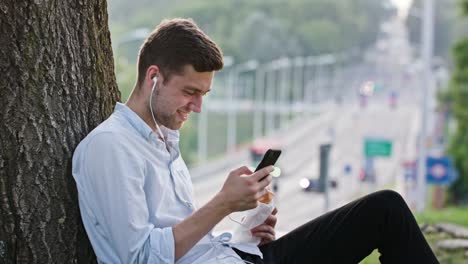 Un-hombre-joven-con-un-móvil-al-aire-libre