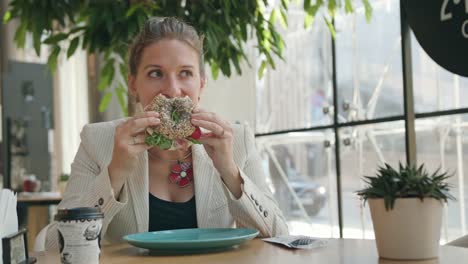 Una-señora-joven-comiendo-Sandwich-en-la-cafetería