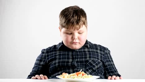 Young-fat-boy-looks-at-salad-and-shows-like-sign-50-fps