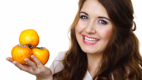 Cheerful-woman-holds-persimmon-kaki-fruits,-isolated