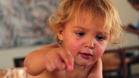 Candid-realen-Moment-der-2-Jahre-altes-Baby-Zeigefinger-an-Nahrung,-die-er-essen-möchte