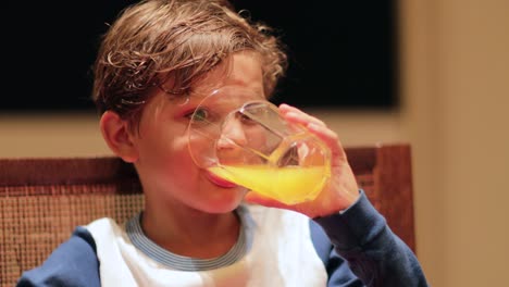 Nahaufnahme-des-jungen-Orangensaft-trinken.-Kind-einen-Schluck-der-Hydratation