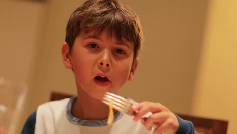 Kind-Nooddle-Nudeln-zum-Abendessen-zu-genießen.-Komisch-übertrieben-expressiv-Kind-Gesicht-Essen-Spaghetti-zum-Abendessen