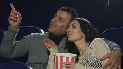 Mature-happy-couple-enjoying-their-date-at-the-cinema-watching-a-movie