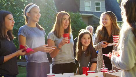 Familie-und-Freunde-sprechen-und-Essen-auf-einer-Block-party