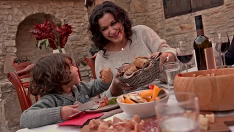 Großmutter-und-Enkel-dem-Mittagessen-mit-der-Familie-in-Haus-im-Dorf