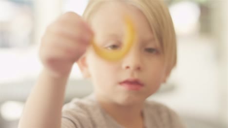 Focusing-shot-of-a-child-holding-a-curly-frie-at-an-outdoor-food-court