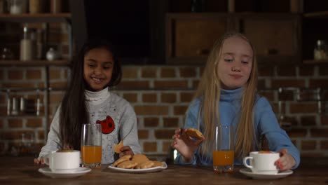 Excited-little-girls-relaxing-together-in-kitchen