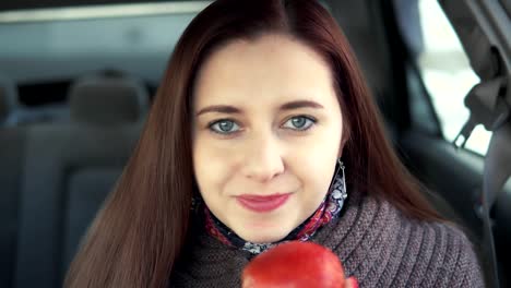 a-woman-eats-an-apple-in-a-car