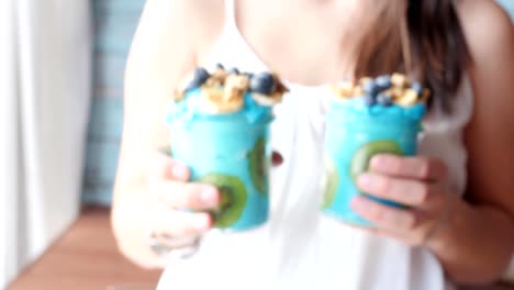 female-hands-holding-blue-majik,-summer-spirulina-smoothie,-showing,-giving,-offering