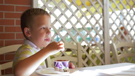 Niño-comer-helado-de-chocolate-en-café-de-verano