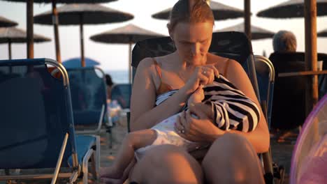 Frau-stillen-Baby-am-Strand