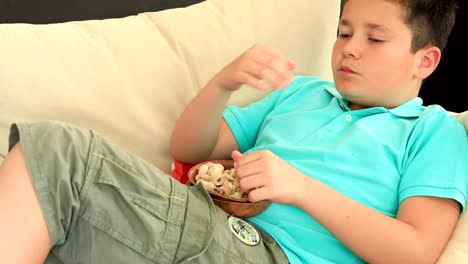 Young-boy-eating-peanut-and-watching-tv