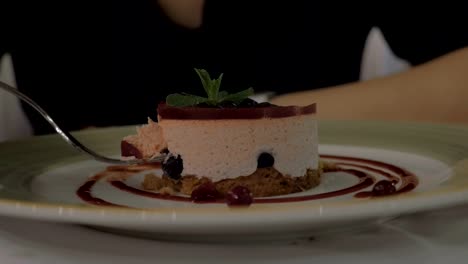 Frau-Essen-Mousse-Dessert-mit-Beeren-im-restaurant