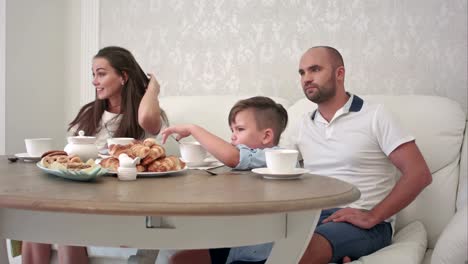 Glückliche-Familie-zusammen-beim-Frühstück-auf-den-Tisch-im-Restaurant-zu-spielen